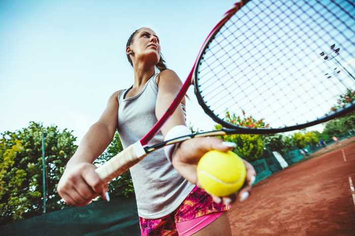 Woman getting ready to serve tennis ball