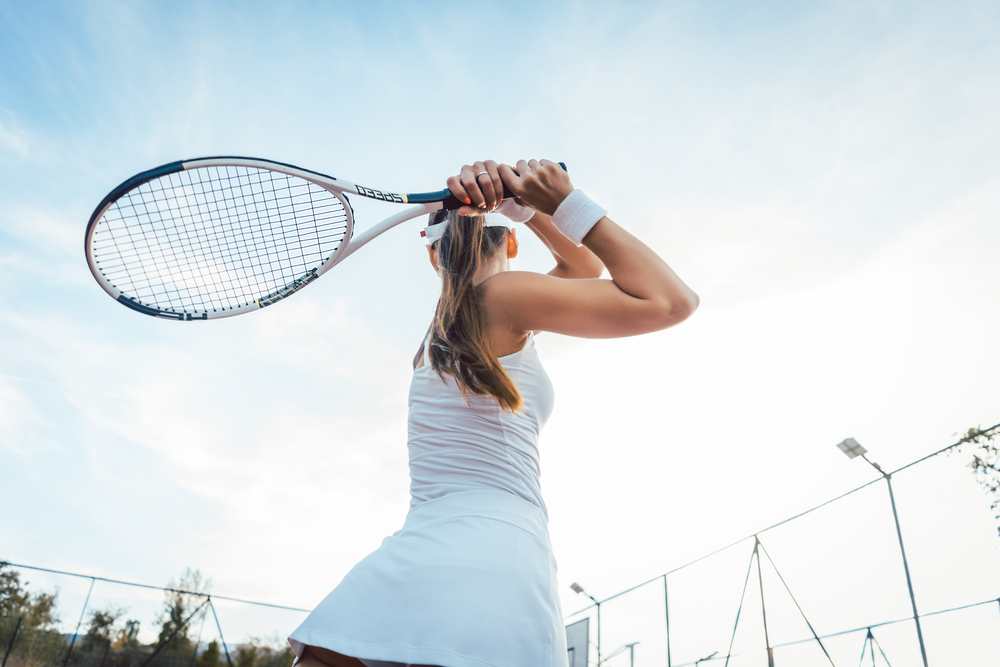 Woman giving return playing tennis on court